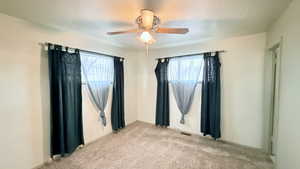 Spare room featuring ceiling fan and light carpet