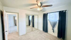 Unfurnished bedroom with light carpet, ceiling fan, and a closet