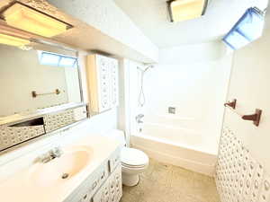 Full bathroom featuring toilet, a healthy amount of sunlight, tub / shower combination, and vanity