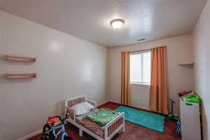 Carpeted bedroom featuring a textured ceiling