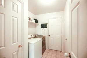 Laundry area featuring independent washer and dryer and a textured ceiling