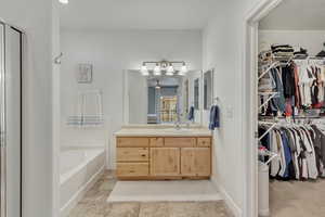 Bathroom with tile patterned flooring, vanity, ceiling fan, and independent shower and bath