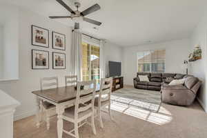 Carpeted dining area with ceiling fan