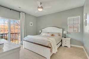 Carpeted bedroom featuring access to exterior, ceiling fan, and multiple windows