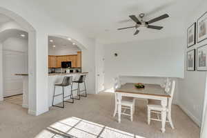 Dining space featuring light colored carpet and ceiling fan