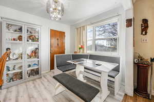 Dining room with a notable chandelier, breakfast area, and light hardwood / wood-style flooring