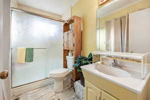 Bathroom with vanity, toilet, and an enclosed shower