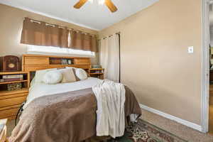 Carpeted bedroom featuring ceiling fan