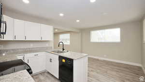 Kitchen with dishwasher, white cabinetry, sink, and kitchen peninsula