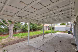 View of patio featuring a storage unit