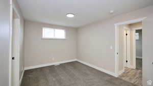 Carpeted spare room with a textured ceiling