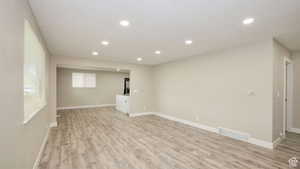 Basement with a textured ceiling and light hardwood / wood-style flooring