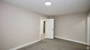 Carpeted empty room with a textured ceiling