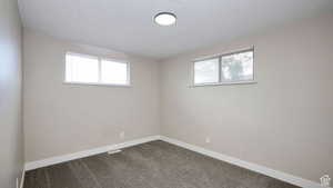 Empty room featuring carpet flooring and a textured ceiling