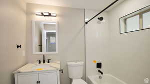 Full bathroom with vanity, toilet, and tiled shower / bath