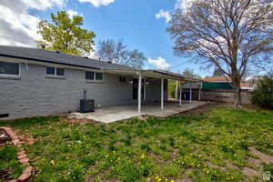 Back of house with a patio area, a yard, and cooling unit