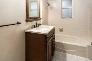 Bathroom with tile patterned flooring, vanity, and tiled shower / bath combo