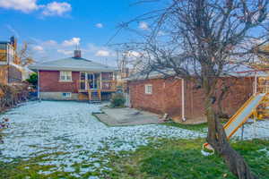 Snow covered property featuring a patio and a deck