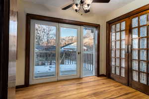 Sunroom, kitchen dining/ doorway to outside, a textured ceiling, and french doors.