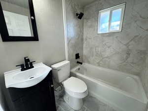 Full bathroom featuring vanity, toilet, and tiled shower / bath combo