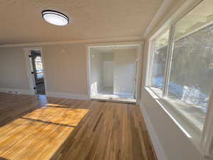 Spare room featuring hardwood / wood-style floors and crown molding