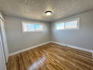 Unfurnished bedroom featuring a textured ceiling and hardwood / wood-style flooring