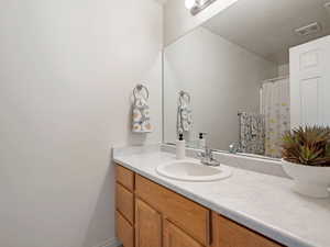 Bathroom with a textured ceiling and vanity