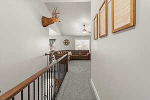 Corridor with carpet and lofted ceiling