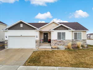 Craftsman inspired home with a garage and a front lawn