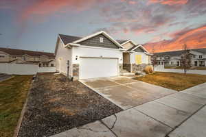 View of front of property with a yard and a garage