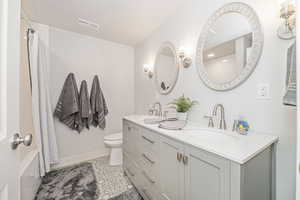 Full bathroom with vanity, toilet, and shower / tub combo