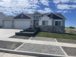 Craftsman-style house with a front yard and a garage