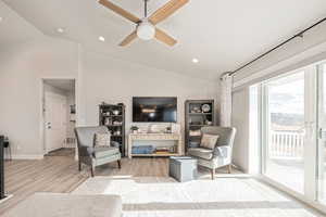 Living room featuring ceiling fan and vaulted ceiling