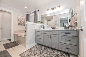 Bathroom with tile flooring, vanity, and tiled tub