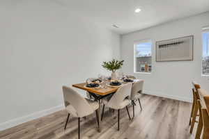 Dining room with light wood-style floors, visible vents, baseboards, and recessed lighting