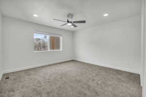 Carpeted spare room featuring recessed lighting, visible vents, ceiling fan, and baseboards