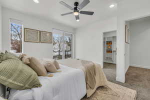 Bedroom featuring carpet, a walk in closet, recessed lighting, ceiling fan, and baseboards