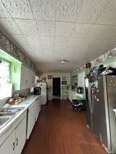 Kitchen featuring white cabinetry, dark hardwood / wood-style flooring, and white appliances