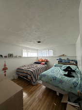 Bedroom with wood-type flooring and a textured ceiling