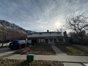 View of front property with a mountain view and a front lawn