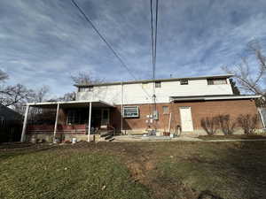 Rear view of property with a yard and a patio