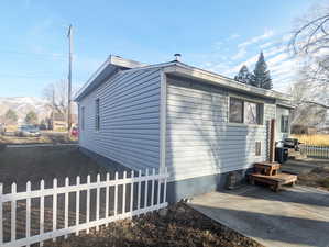 View of side of home featuring a patio area and a mountain view