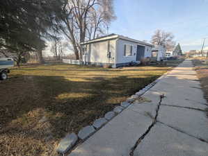 View of side of home featuring a yard