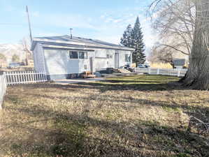 Rear view of property featuring central AC unit, a patio area, and a lawn