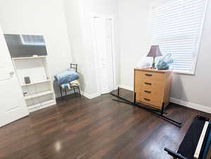 Bedroom with a closet and dark hardwood / wood-style flooring