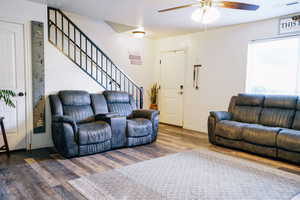 Living room with ceiling fan and dark hardwood / wood-style floors