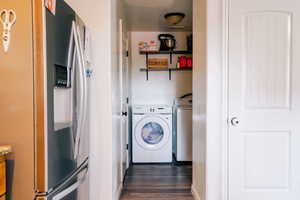 Washroom featuring dark hardwood / wood-style flooring and washer and dryer