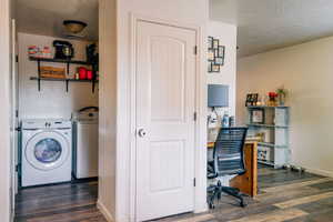 Laundry area with washing machine and clothes dryer, dark wood-type flooring, and a textured ceiling