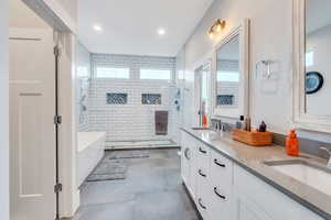 Bathroom with vanity and shower with separate bathtub