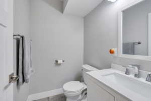 Bathroom featuring tile patterned floors, vanity, and toilet